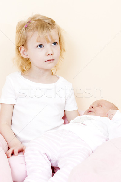 portrait of a little girl cradling her one month old baby sister Stock photo © phbcz
