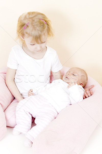 portrait of a little girl cradling her one month old baby sister Stock photo © phbcz