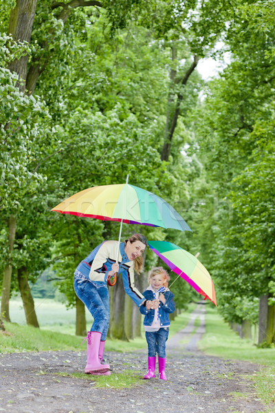 mother and her daughter with umbrellas in spring alley Stock photo © phbcz