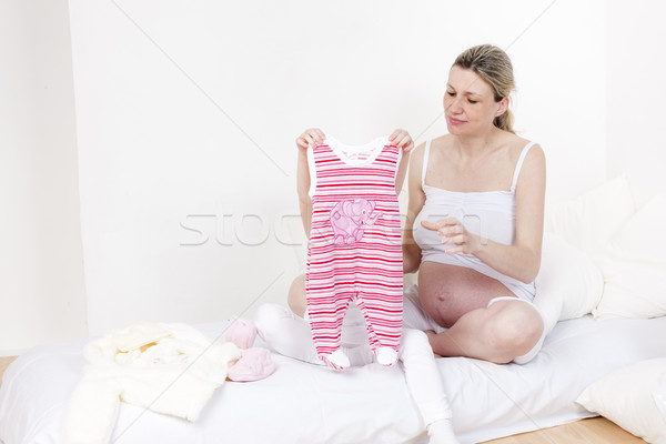 little girl and her pregnant mother with clothes for a baby Stock photo © phbcz