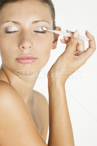 portrait of young woman putting on eye shadows Stock photo © phbcz