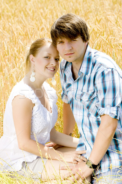 young couple sitting in grain field Stock photo © phbcz
