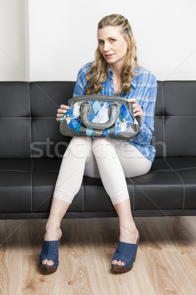 женщину джинсовой сумочка сидят диван Сток-фото © phbcz