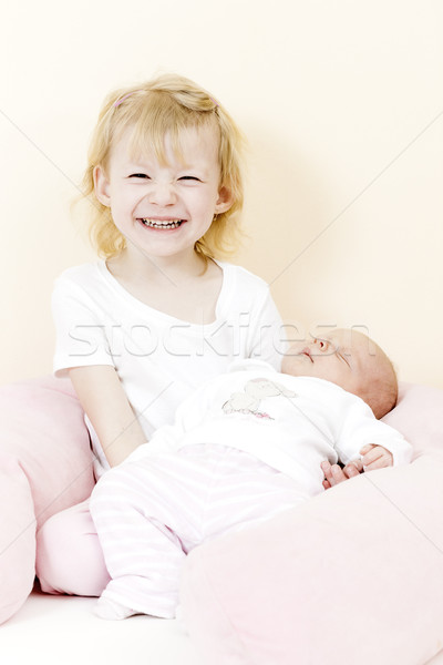 Stock photo: portrait of a little girl cradling her one month old baby sister