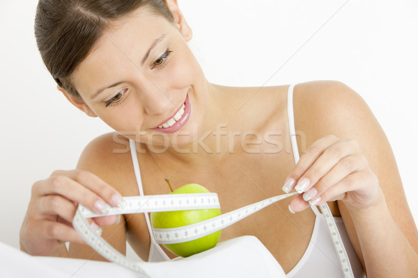 portrait of young woman with green apple and tape measure Stock photo © phbcz
