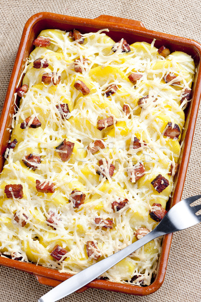 potatoes and bacon baked with pecorino cheese Stock photo © phbcz