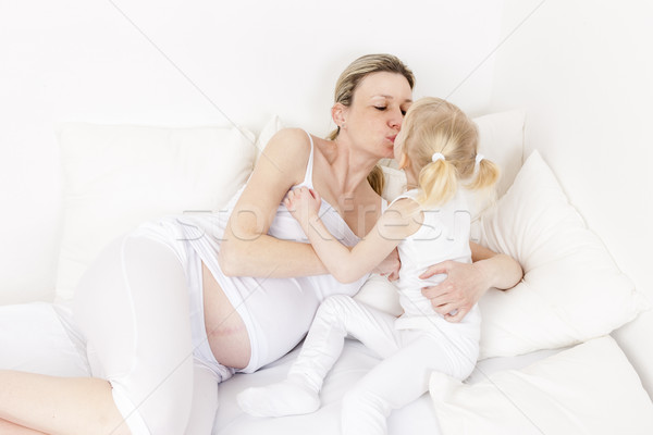 little girl with her pregnant mother resting in bed Stock photo © phbcz