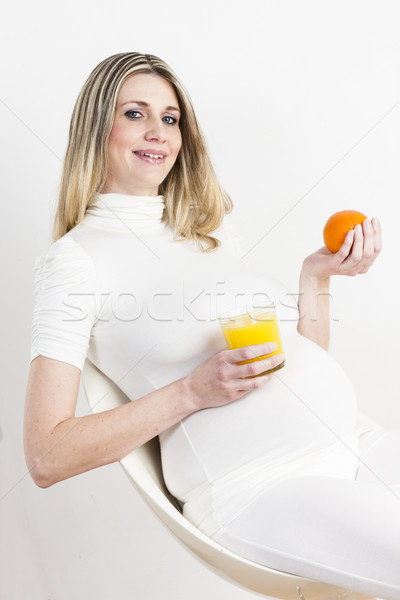 Stock photo: portrait of pregnant woman with a glass of orange juice and an o