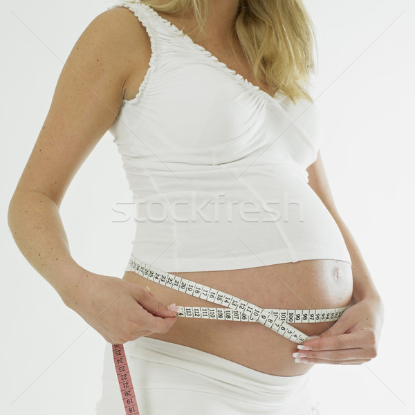 Stock photo: pregnat woman with tape measure