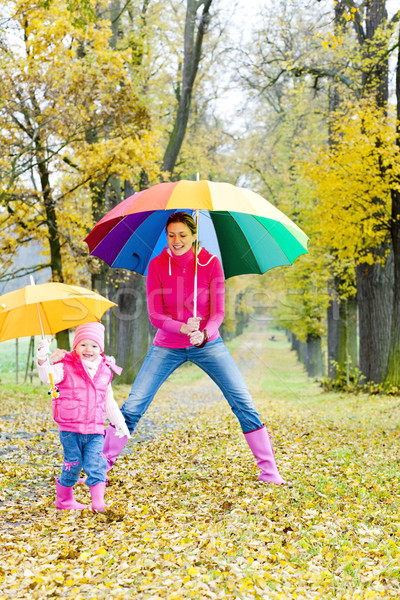 mother and her daughter with umbrellas in autumnal alley Stock photo © phbcz