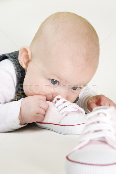 portrait of lying down baby girl holding shoes Stock photo © phbcz