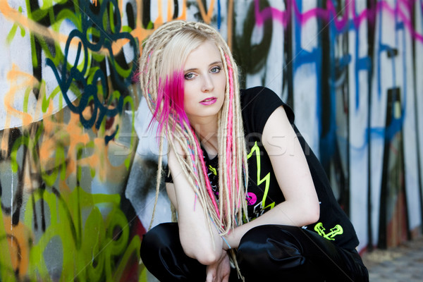 portrait of young woman sitting at graffitti wall Stock photo © phbcz