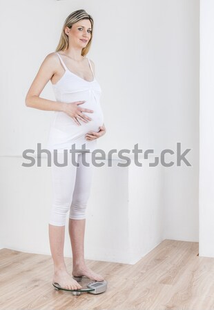 pregnant woman wearing lingerie standing on a weight scale with  Stock photo © phbcz