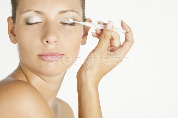 portrait of young woman putting on eye shadows Stock photo © phbcz