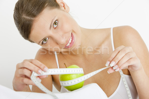 portrait of young woman with green apple and tape measure Stock photo © phbcz