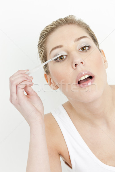 portrait of young woman putting on eye shadows Stock photo © phbcz