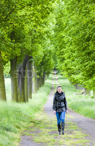 woman wearing rubber boots walking in spring alley Stock photo © phbcz