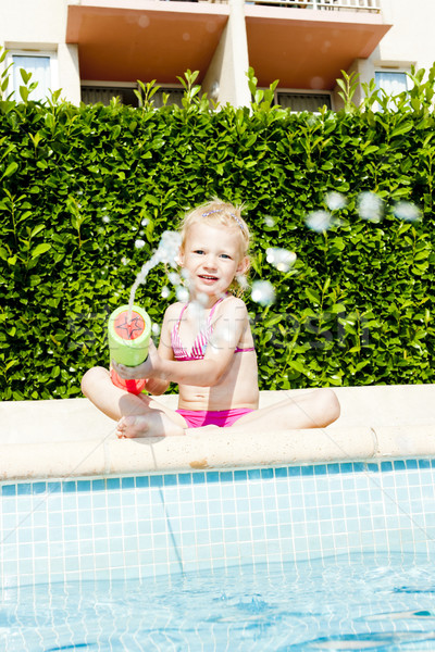 little girl with water sprayer by swimming pool Stock photo © phbcz