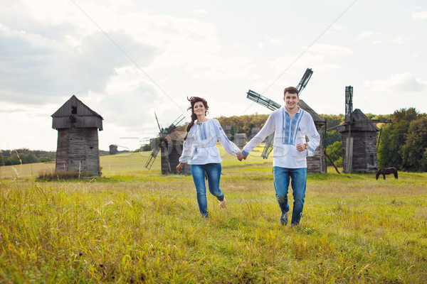 Happy young couple running on the field Stock photo © photobac