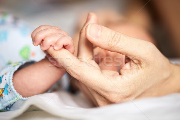 Stock photo: Newborn baby holding mother's hand