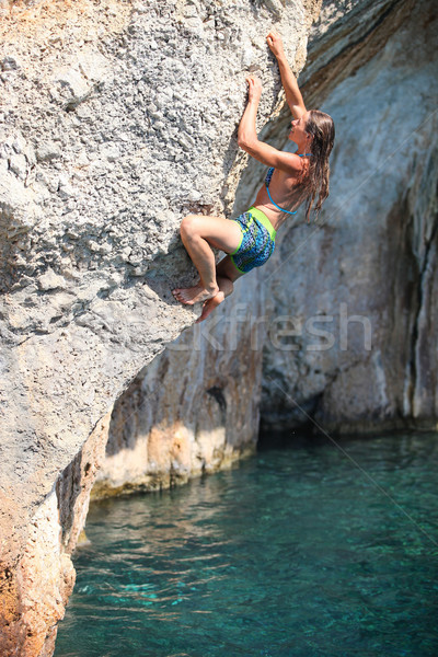 Deep water soloing, female rock climber on cliff Stock photo © photobac