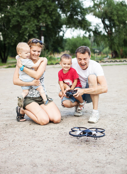 Young family with two boys playing with RC toy Stock photo © photobac