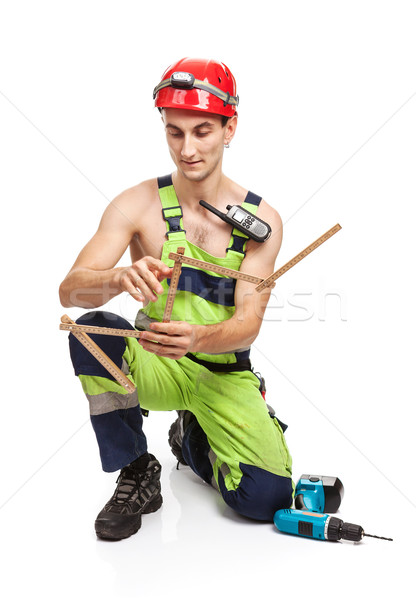 Young handsome contractor holding ruler on white Stock photo © photobac