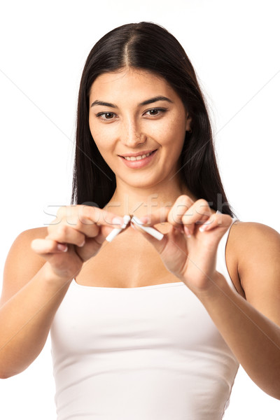 Young woman breaking a cigarette over white Stock photo © photobac