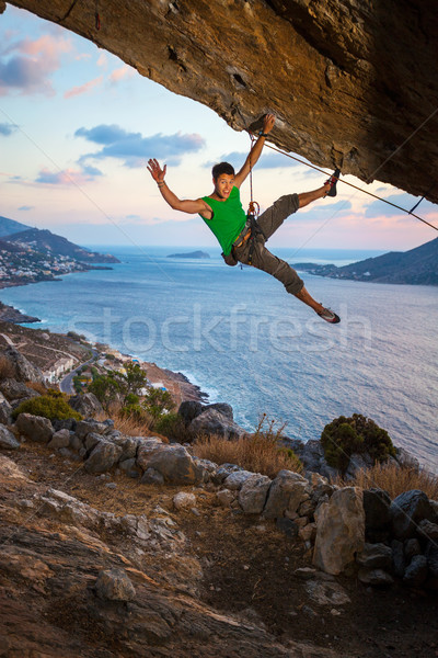 Rock climber waving his hand while climbing Stock photo © photobac