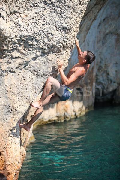 Deep water soloing, rock climber on cliff Stock photo © photobac