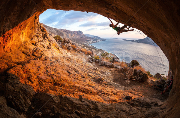 Male rock climber climbing along a roof in a cave Stock photo © photobac