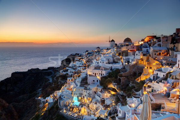 Oia town on Santorini island, Greece at sunset. Famous windmills Stock photo © photocreo