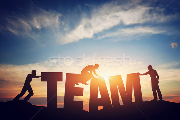 People connect letters to compose the team word. Teamwork concept Stock photo © photocreo