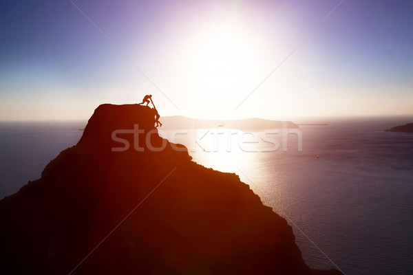 Climber giving hand and helping his friend to reach the top of the mountain. Help, support Stock photo © photocreo