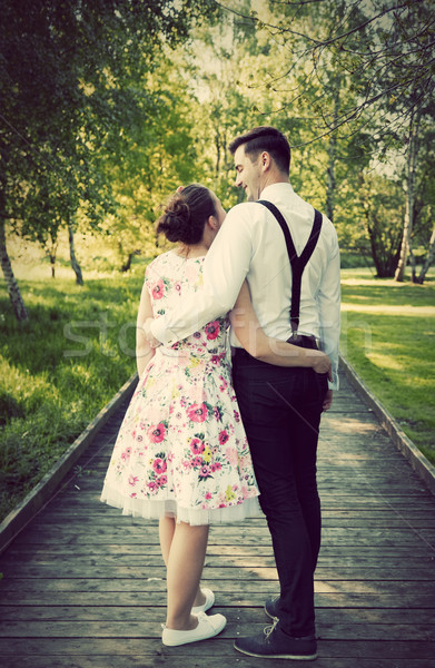 Young couple embrace while standing on wooden path Stock photo © photocreo