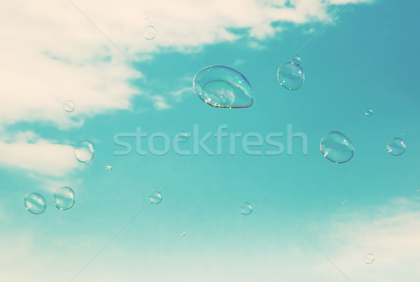 Soap bubbles flying in the air. Puffy clouds sky. Vintage Stock photo © photocreo