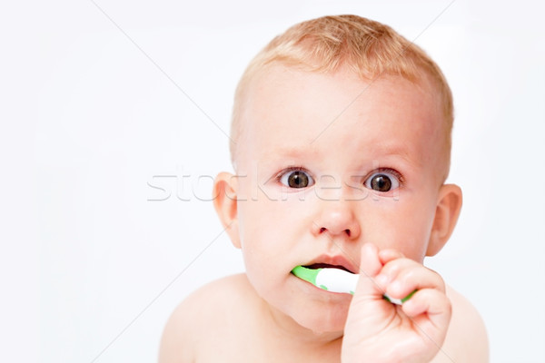 Cute baby brushing his teeth on white Stock photo © photocreo