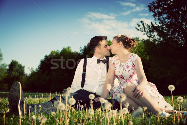 Romantic couple in love about to kiss sitting on grass. Vintage Stock photo © photocreo