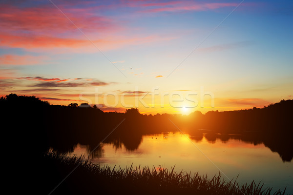 Lake in forest at sunset. Romantic sky with red clouds Stock photo © photocreo