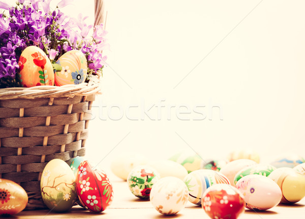 Stock photo: Colorful hand painted Easter eggs in basket and on wood. Handmade vintage decoration