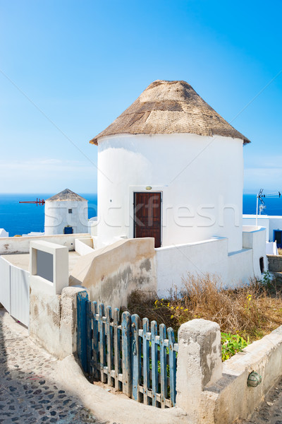 Famous windmills in Oia town on Santorini island, Greece. Stock photo © photocreo