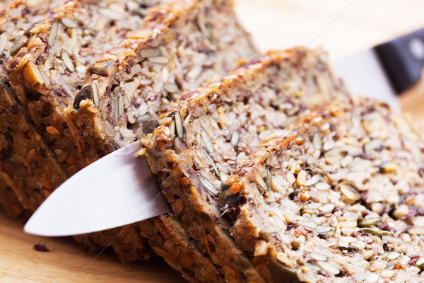 Knife in wholemeal, wholewheat bread on wooden table. Organic, healthy food Stock photo © photocreo