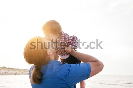 Young father holding his child on the beach and kissing with love Stock photo © photocreo
