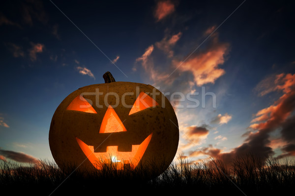 Halloween pumpkin glowing under dark sunset, night sky. Jack o'lantern Stock photo © photocreo