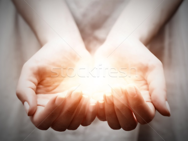 The light in young woman hands. Sharing, giving, offering, protection Stock photo © photocreo