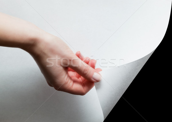 Hand pulling a paper corner to uncover, reveal something Stock photo © photocreo