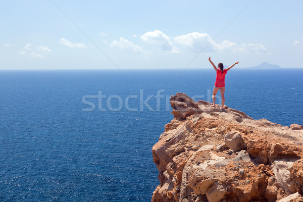 Happy woman on the rock with hands up. Winner, success, travel. Stock photo © photocreo