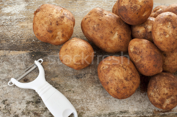 Plastic and metal peeler with raw potatoes Stock photo © photohome