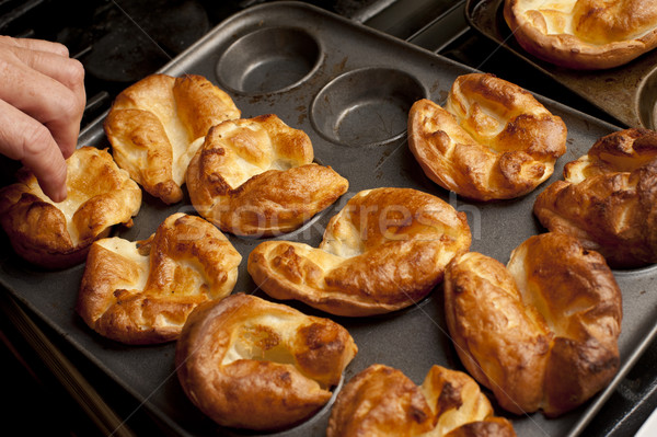 Man removing Yorkshire puddings from a baking tray Stock photo © photohome
