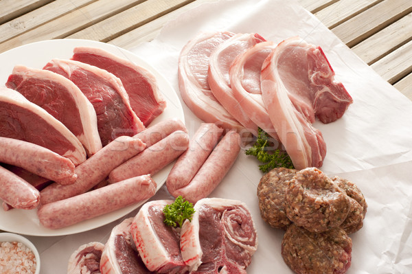 Wooden table set with selection of meat cuts Stock photo © photohome